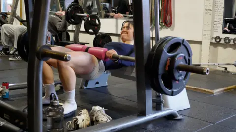 Sarah Mackay Sarah Mackay is pictured doing hip thrusts with a barbell in the gym.