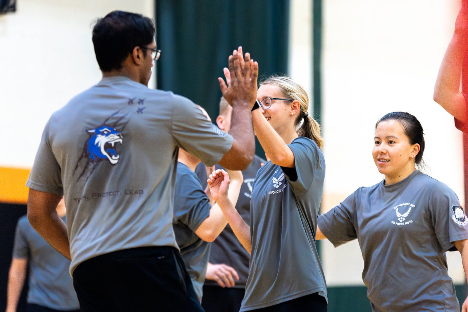 Students giving a high five on the volleyball court