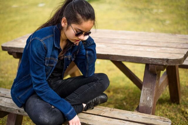 photo - Teen Sitting at Picnic Table